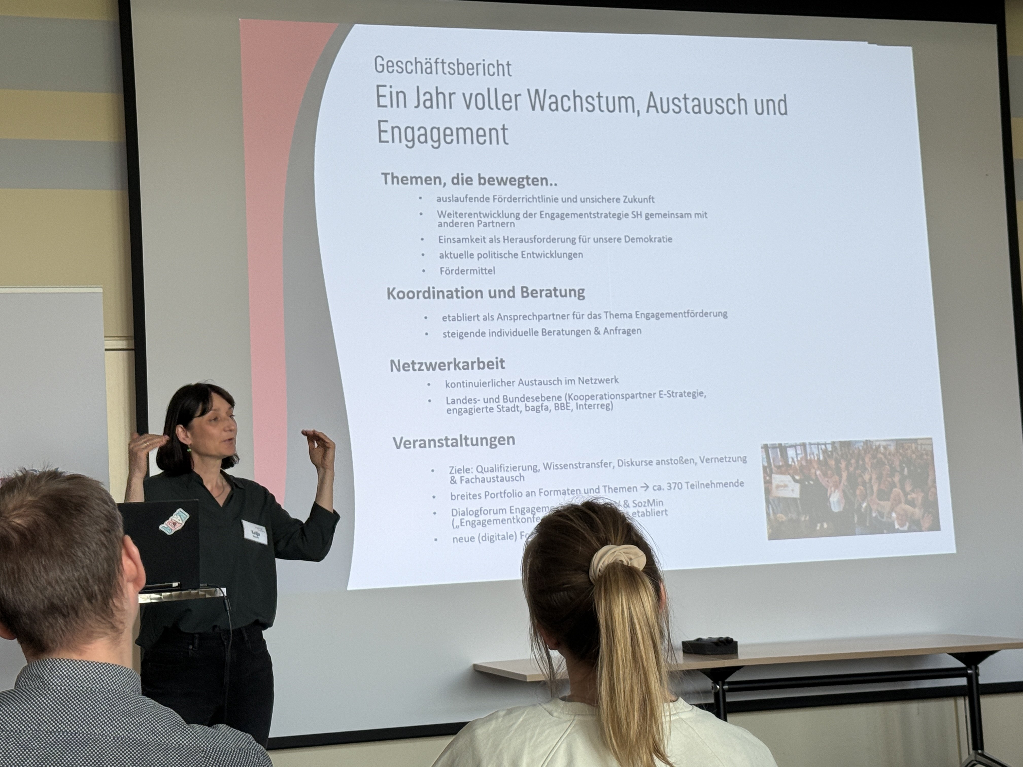 Katja Nowroth führt in den Tag ein. Sie steht vor einer Leinwand auf der eine Projektion zu sehen ist.