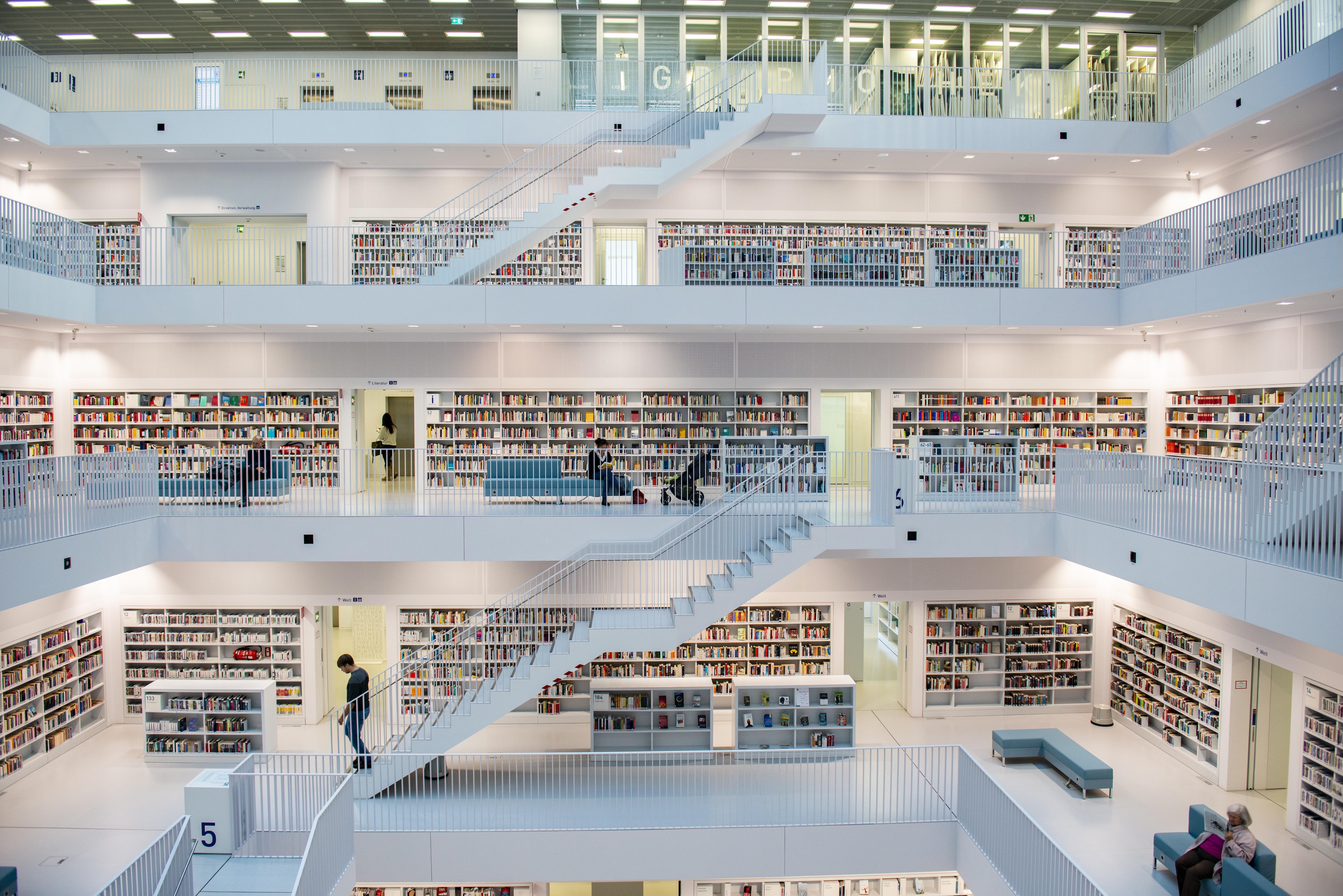 Ein Blick in eine sehr helle öffentliche Bibliothek, die über mehrere Etagen geht.